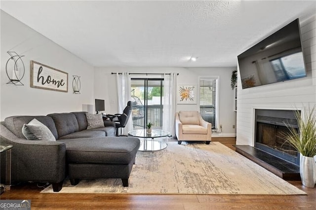 living room with dark hardwood / wood-style flooring and a large fireplace