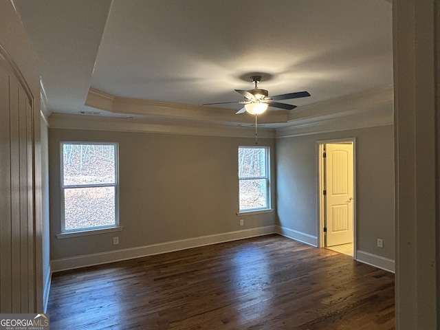 unfurnished room featuring a raised ceiling, ceiling fan, and dark wood-type flooring