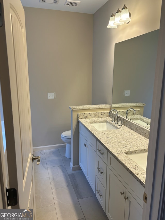 bathroom with tile patterned flooring, vanity, and toilet