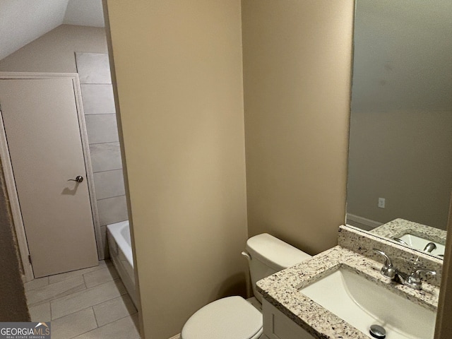 bathroom with vanity, lofted ceiling, tile patterned flooring, toilet, and a tub to relax in