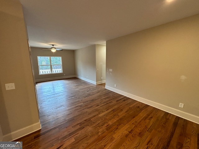 unfurnished room featuring ceiling fan and dark wood-type flooring