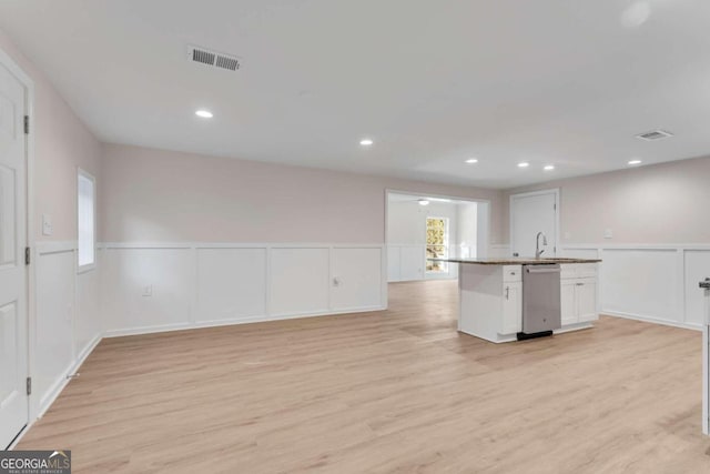 kitchen featuring dishwasher, light hardwood / wood-style floors, white cabinetry, and sink