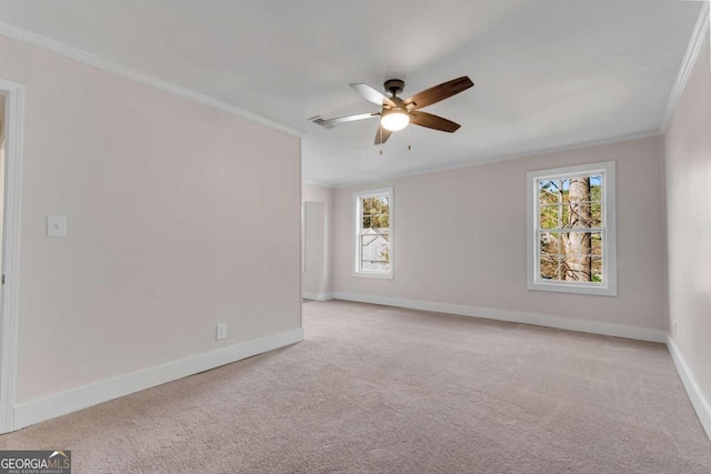 spare room with light carpet, ornamental molding, and a healthy amount of sunlight