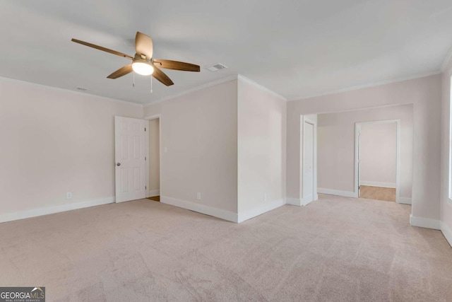 empty room with ceiling fan, light colored carpet, and crown molding