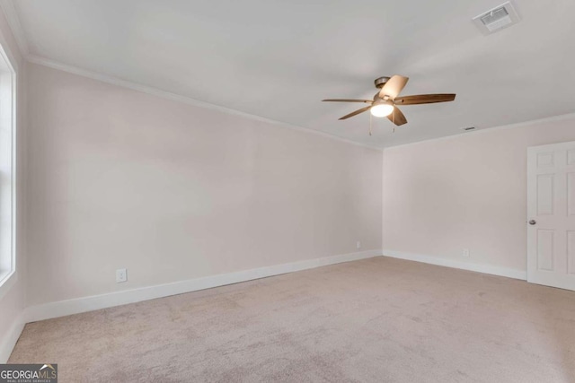 carpeted empty room with ceiling fan and crown molding