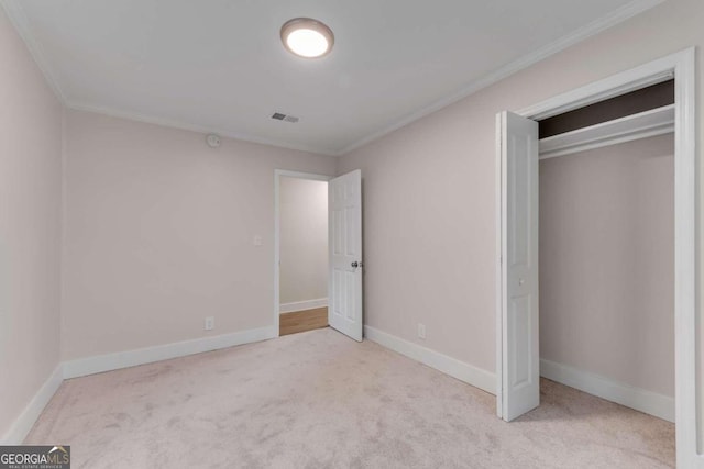 unfurnished bedroom featuring light carpet, a closet, and ornamental molding