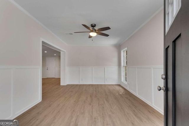 spare room featuring ceiling fan, light hardwood / wood-style floors, and ornamental molding