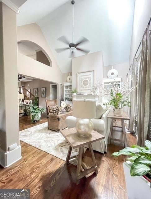 living area featuring ceiling fan, hardwood / wood-style floors, and high vaulted ceiling