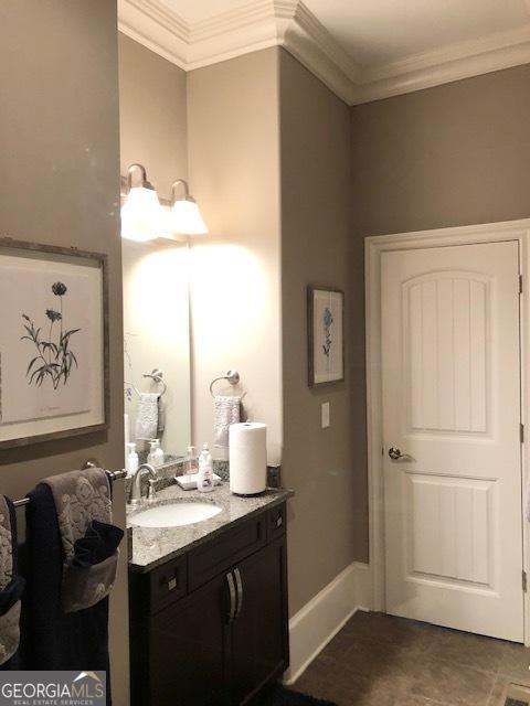 bathroom with tile patterned floors, vanity, and ornamental molding