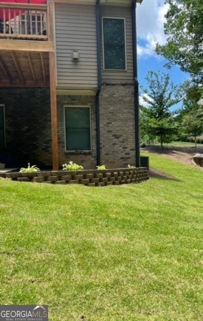 view of home's exterior with a lawn and a balcony