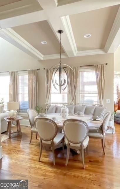 dining space featuring light hardwood / wood-style flooring, a notable chandelier, and crown molding