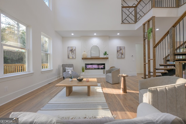 living room with a towering ceiling and wood-type flooring