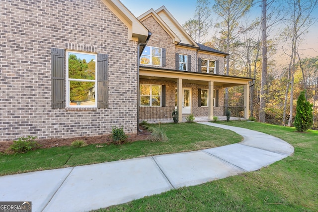 view of front of house with covered porch and a lawn