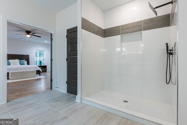 bathroom with hardwood / wood-style flooring, ceiling fan, and a tile shower