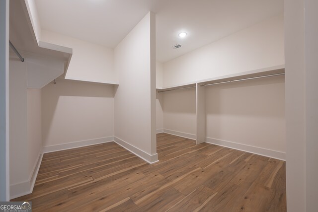 spacious closet with dark hardwood / wood-style floors