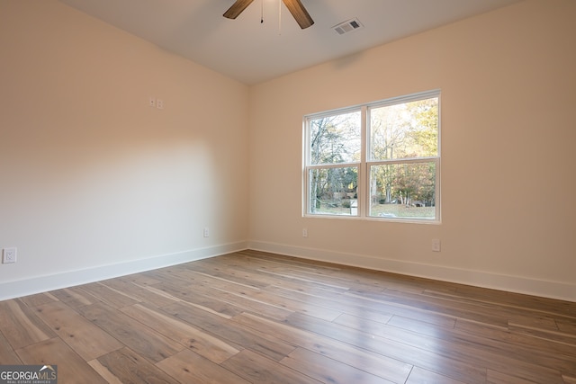 spare room featuring hardwood / wood-style floors and ceiling fan