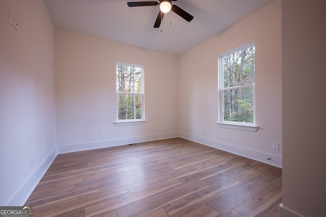 unfurnished room featuring ceiling fan, a healthy amount of sunlight, and light wood-type flooring