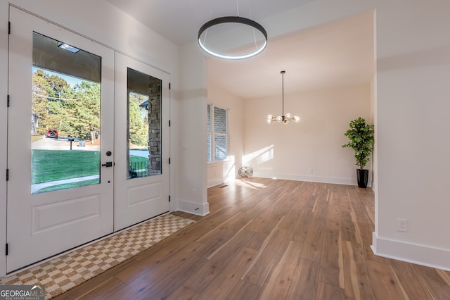 doorway featuring wood-type flooring and an inviting chandelier