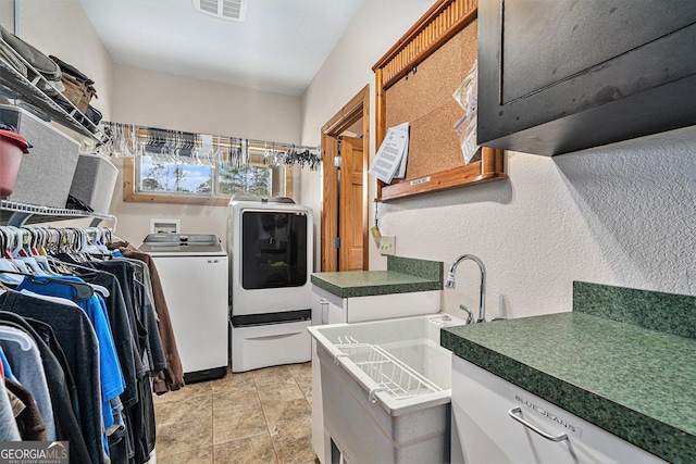 interior space featuring light tile patterned flooring, white cabinets, and washing machine and clothes dryer