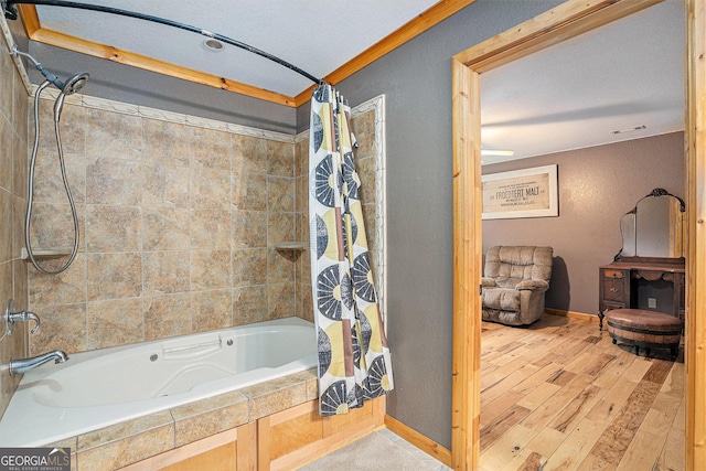 bathroom with a textured ceiling, crown molding, hardwood / wood-style floors, and shower / bath combo