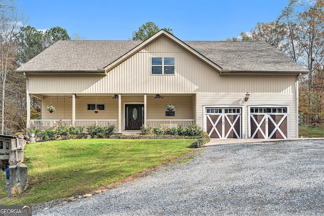 view of front facade featuring a garage, covered porch, and a front lawn