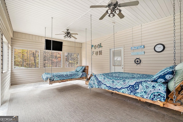 bedroom with ceiling fan and wooden walls