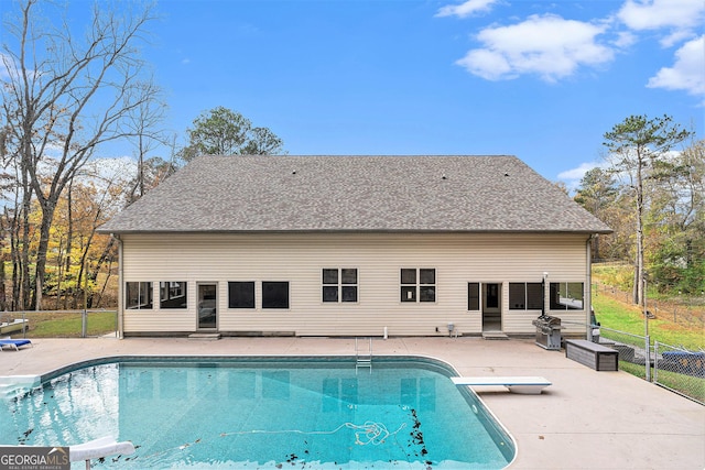 view of swimming pool featuring a patio and a diving board