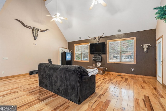 living room featuring ceiling fan, light wood-type flooring, and high vaulted ceiling