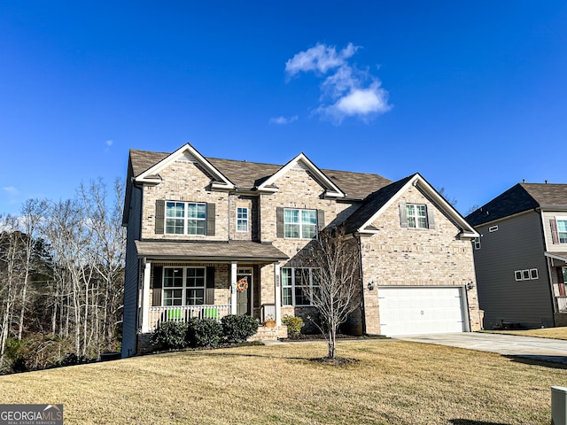 view of front of house featuring a front lawn, covered porch, and a garage