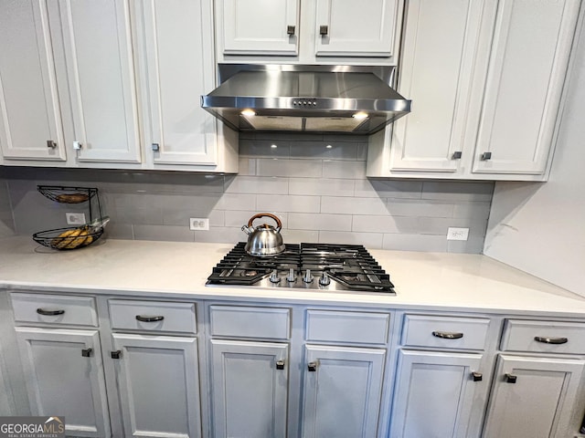 kitchen featuring backsplash, stainless steel gas cooktop, and wall chimney range hood