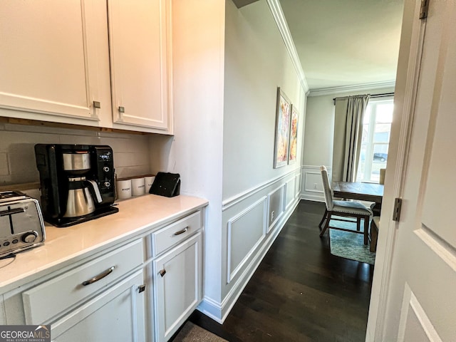 bar featuring white cabinets, dark wood-type flooring, and crown molding