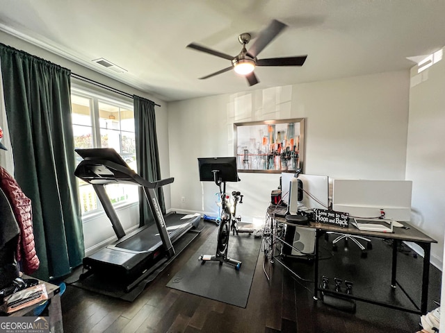 workout area featuring ceiling fan and dark wood-type flooring