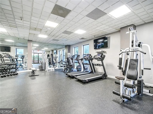 gym with a drop ceiling and a healthy amount of sunlight