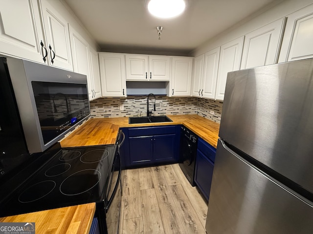 kitchen featuring blue cabinetry, sink, wood counters, white cabinets, and appliances with stainless steel finishes