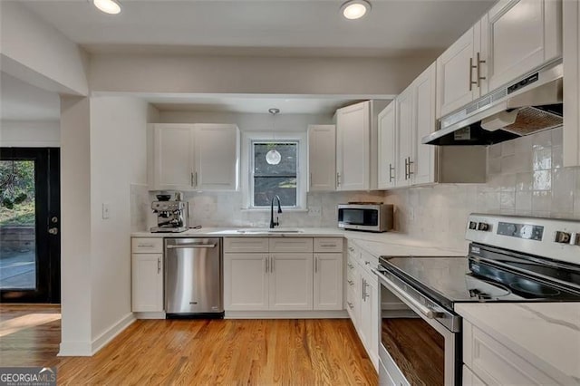 kitchen featuring white cabinetry, sink, light wood-type flooring, and appliances with stainless steel finishes