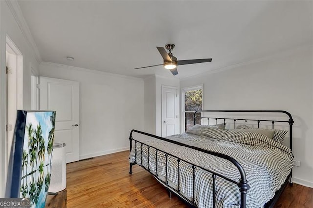 bedroom with hardwood / wood-style floors, ceiling fan, and ornamental molding