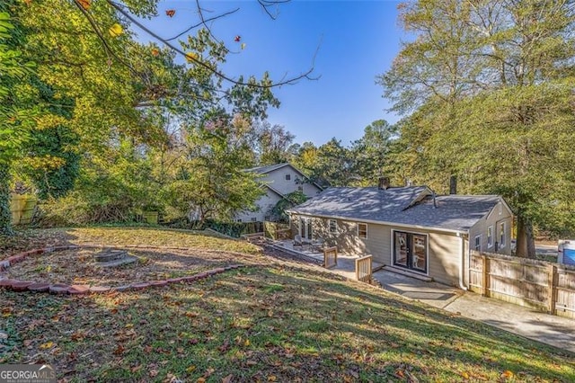 back of house featuring a lawn and a patio area