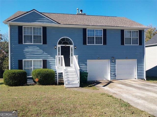 bi-level home with a garage and a front lawn