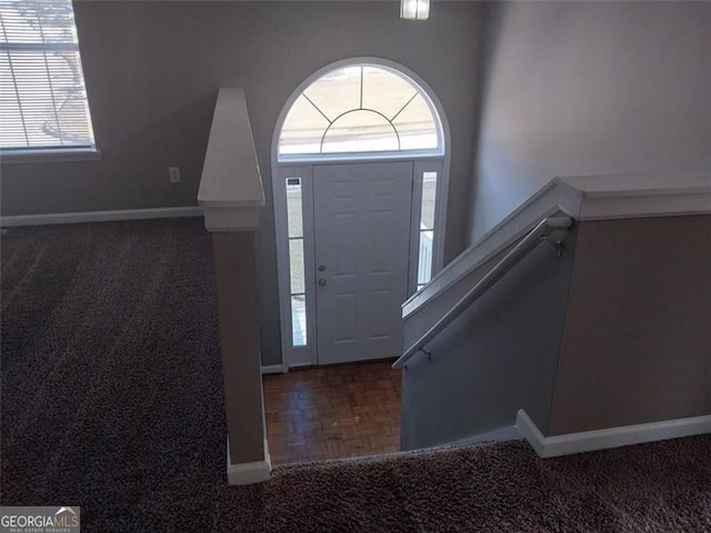 foyer featuring dark parquet flooring and plenty of natural light