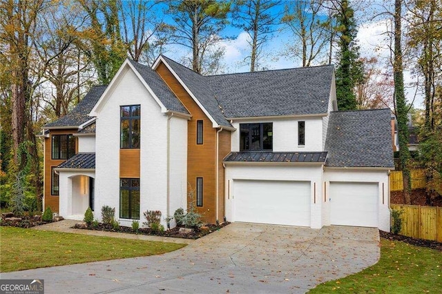 modern farmhouse with a front yard and a garage