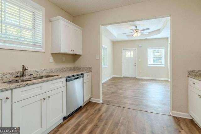 kitchen with stainless steel dishwasher, light hardwood / wood-style floors, white cabinets, and sink