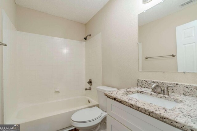 full bathroom with vanity, a textured ceiling, toilet, and shower / bathtub combination