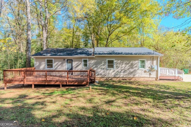 rear view of house with a yard and a deck