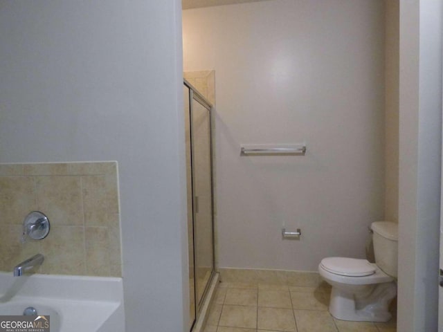 bathroom featuring tile patterned flooring, a shower, and toilet