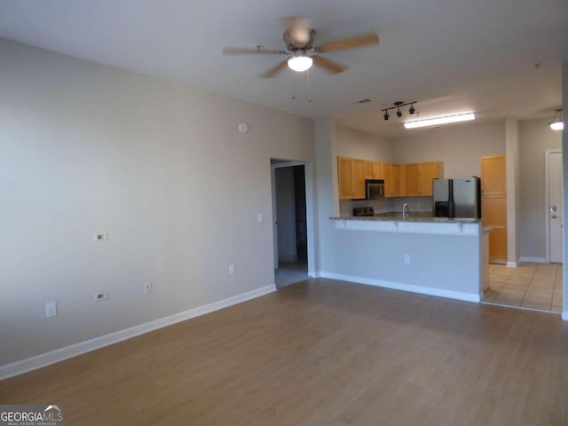 kitchen featuring kitchen peninsula, ceiling fan, light hardwood / wood-style floors, and appliances with stainless steel finishes