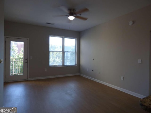 unfurnished room featuring dark hardwood / wood-style floors, ceiling fan, and a healthy amount of sunlight