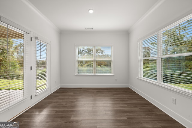 spare room featuring dark hardwood / wood-style floors and crown molding