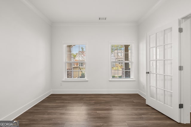 spare room featuring dark hardwood / wood-style flooring and crown molding