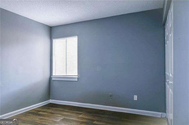 doorway to outside with dark hardwood / wood-style flooring and a textured ceiling