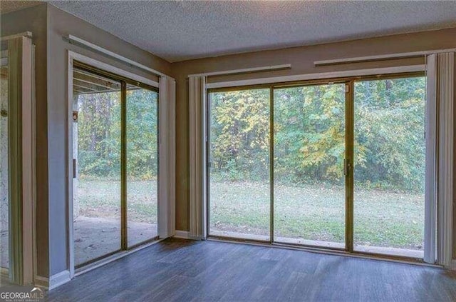 doorway to outside with hardwood / wood-style flooring and a textured ceiling